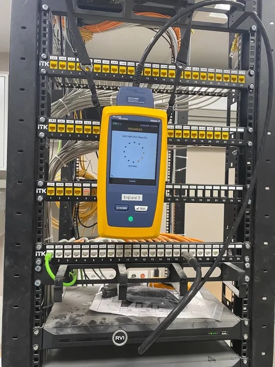 Fluke DSX-5000 на фоне патч-панелей с промаркированными портами
